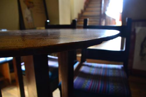 a wooden table with chairs and stairs in the background at El Cafecito Hostel Cuenca in Cuenca