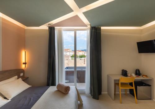 a bedroom with a bed and a desk and a window at Cozy Rooms in Senorbì