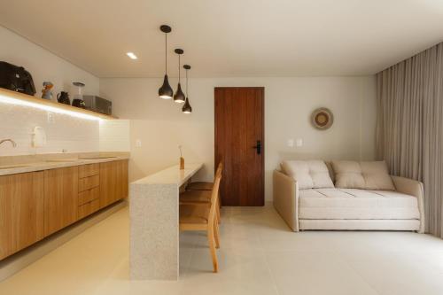 una cucina e un soggiorno con un divano e un tavolo di Jubarte Flats a Itacaré