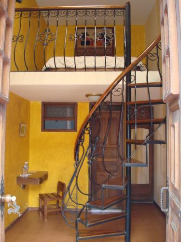 a spiral staircase in a room with a bunk bed at Hotel San Francisco De Quito in Quito