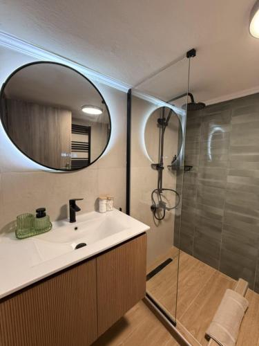 a bathroom with a sink and a shower with a mirror at La Casa in Kozani