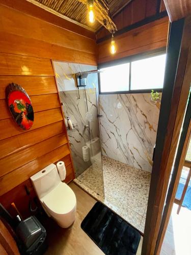 a bathroom with a toilet and a shower at Cabaña Río San Carlos Ecolodge in Boca Tapada