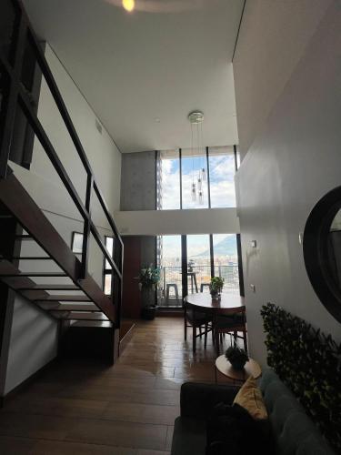 a living room with a spiral staircase and a table at Penthouse en Centro de Monterrey in Monterrey