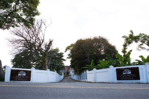 a white fence in front of a house at Hotel Boutique El Triángulo in Armenia