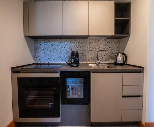 een kleine keuken met een spoelbak en een fornuis bij Des Bains Acireale in Acireale