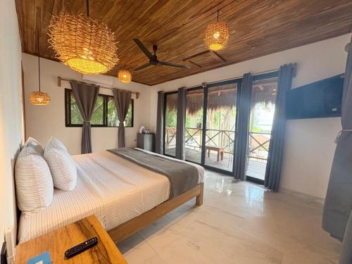 a bedroom with a bed and some windows at Hotel Isabella Bacalar Lake Front in Bacalar