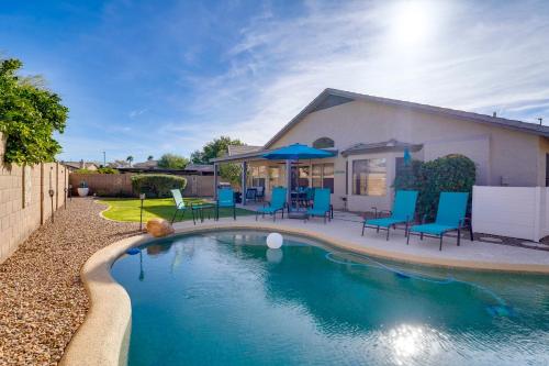 a swimming pool with blue chairs and a house at Close to Spring Training! Outdoor Oasis in Gilbert in Gilbert