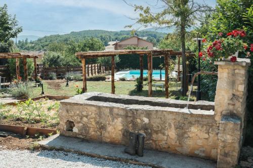 een stenen put in een tuin met een vijver bij Country House Il Vecchio Ippocastano Adults only in Cascia