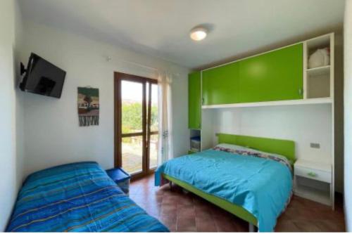 ein Schlafzimmer mit zwei Betten und einem Fernseher darin in der Unterkunft Casa vacanza San Teodoro in San Teodoro