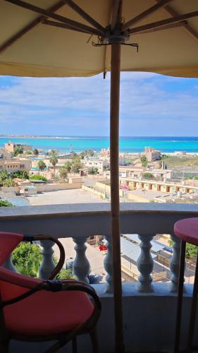 uma varanda com vista para a praia e para o oceano em أراكِ قريبا صينين فقط em Marsa Matruh