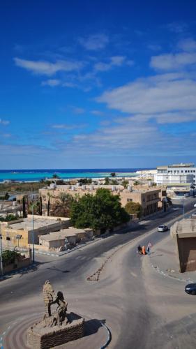uma rua com uma estátua no meio de uma cidade em أراكِ قريبا صينين فقط em Marsa Matruh