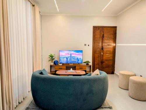 a living room with a blue couch and a table at Hakuna Matata, 3 min to Speke Resort, Opposite Caramel, Munyonyo in Kampala