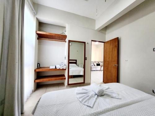 een slaapkamer met een wit bed met een boog erop bij Hotel Otoch Apartments in Telchac