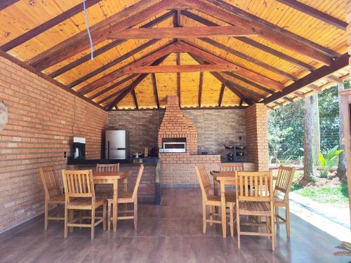 un patio con tavoli e sedie in legno e un camino di Trilha das Siriemas a Tiradentes