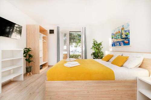 una camera da letto con un grande letto con una coperta gialla di Guest House Kovacevic a Hvar