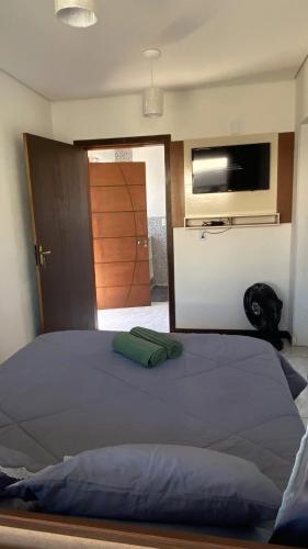 a bedroom with a large bed with a flat screen tv at Casinha com área externa in Florianópolis