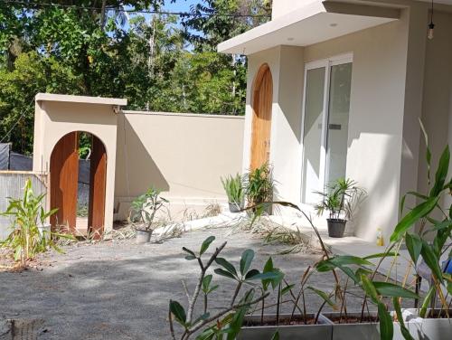een wit huis met planten ervoor bij LUSSO Mirissa in Mirissa