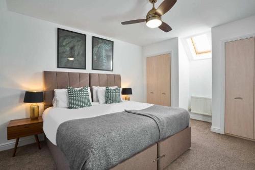 une chambre avec un grand lit et un ventilateur de plafond dans l'établissement Cornish Haven -Spacious 4 Bed House by Launceston, à Launceston