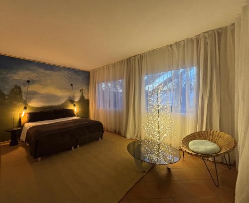 a bedroom with a bed and a christmas tree in it at Suite Vigia Jardim in Jardim do Mar