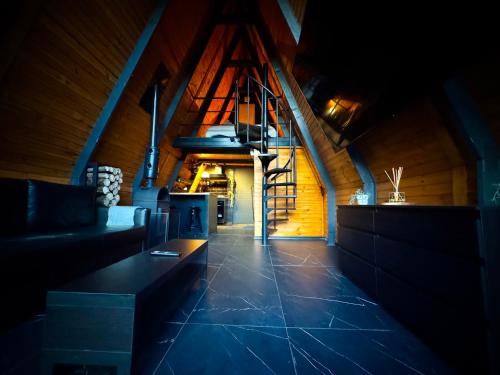 een woonkamer met een trap in een huis bij M Cabin A Frame Predeal 2 Ciubar in Predeal
