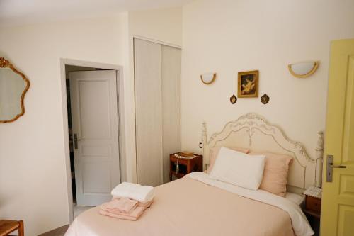 ein Schlafzimmer mit einem weißen Bett mit einem rosa Handtuch darauf in der Unterkunft LaPetite Maison Abigail, Peaceful home in Avignon in Avignon