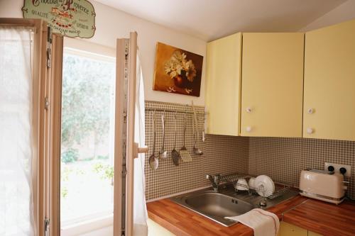 eine Küche mit gelben Schränken und einem Waschbecken in der Unterkunft LaPetite Maison Abigail, Peaceful home in Avignon in Avignon