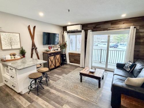 a kitchen and living room with a couch and a table at Loon Mountain Retreat with Pool and Hot Tub in Lincoln
