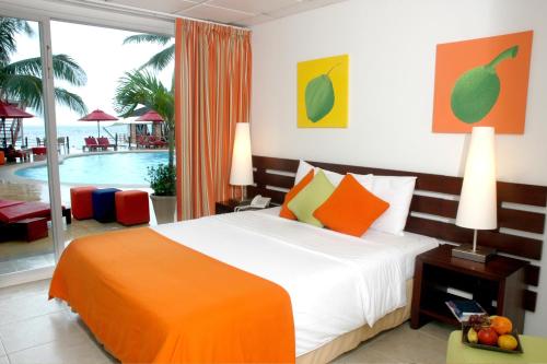 1 dormitorio con cama y piscina en Decameron Los Delfines - All Inclusive, en San Andrés