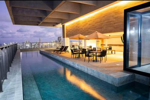 - une piscine avec des tables et des chaises dans un bâtiment dans l'établissement Max Derby 701, à Récife