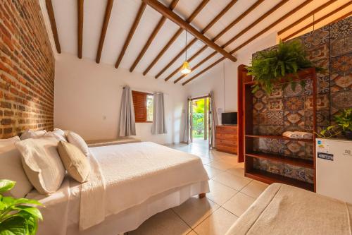 una camera da letto con un letto e un muro di mattoni di Pousada Arraial dos Sonhos a Arraial d'Ajuda