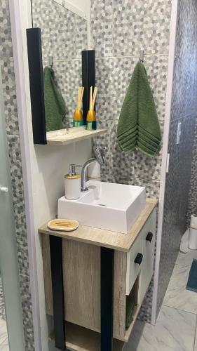 a bathroom with a sink and a mirror at Casinha com área externa in Florianópolis