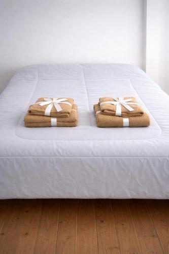 a bed with two towels on top of it at amailen ushuaia in Ushuaia