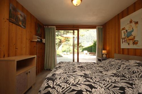 une chambre avec un lit avec une couverture noire et blanche dans l'établissement Appartement 2 pers hyper centre Chamonix, à Chamonix-Mont-Blanc