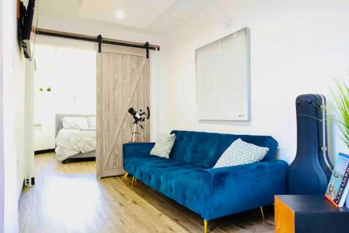 a blue couch in a living room with a bedroom at Casa Vagon Isla Bendita in La Gonzalez