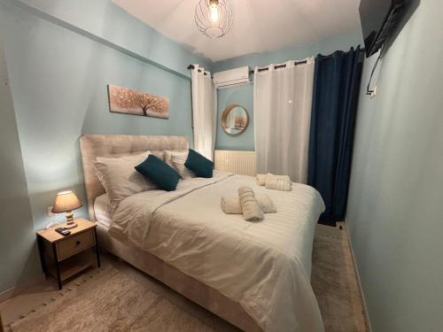 a bedroom with a large bed with blue walls at Kalavryta Moments in Kalavrita