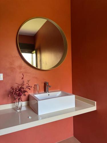 a bathroom with a white sink and a mirror at El Roble, casitas rurales in Valverde de la Vera