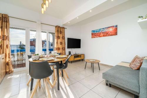 un soggiorno con un tavolo e un divano di Sunlit Balcony & Open Space Flat by HostWise a Vale de Pedras