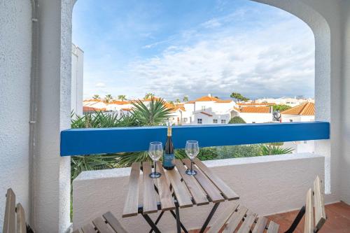 un tavolo con bicchieri da vino su un balcone di Sunlit Balcony & Open Space Flat by HostWise a Vale de Pedras