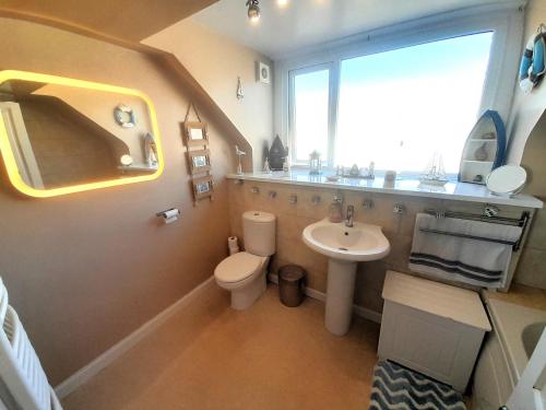 een badkamer met een wastafel en een toilet en een raam bij 1 Bed in St Monans 41693 in Saint Monance