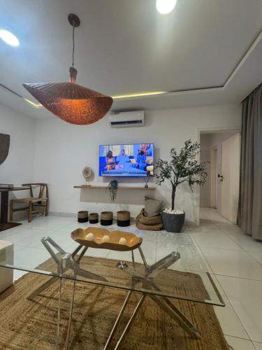 a living room with a glass table and a tv at ORY luxury garden in Abidjan