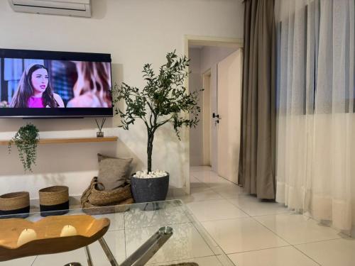 ein Wohnzimmer mit einem Flachbildfernseher an der Wand in der Unterkunft ORY luxury garden in Abidjan