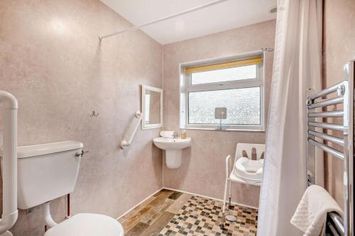 a bathroom with a toilet sink and a window at 2 Bed in Snettisham oc-s28186 in Snettisham