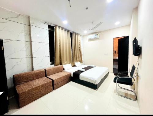 a hotel room with a bed and a couch at Hotel Rukmani Palace in Ujjain
