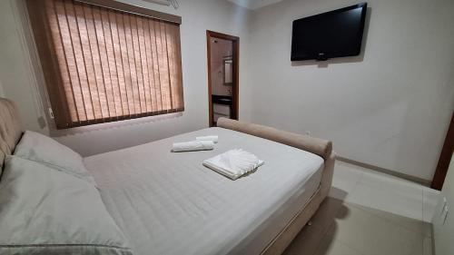 a bedroom with a bed with two towels on it at Casa Requinte in Cascavel