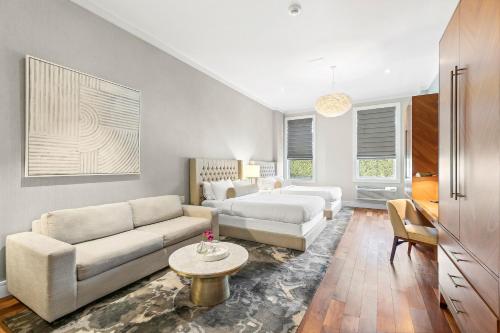 a living room with a couch and a table at Hotel Suites at Vanderbilt in Westbury