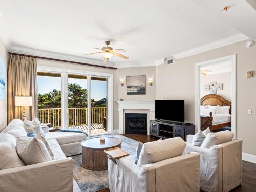 a living room with two couches and a fireplace at Sanctuary at Redfish 3119 by Newman-Dailey in Santa Rosa Beach