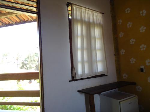 a window in a room with a microwave next to it at Pousada Doromari in Taíba