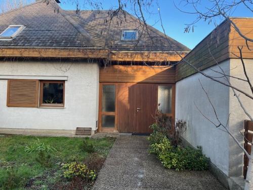 een huis met een houten deur in een tuin bij Villa Pdorf in Perchtoldsdorf