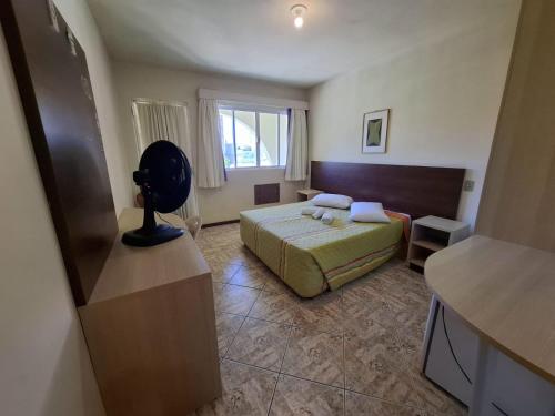 ein kleines Schlafzimmer mit einem Bett und einem Fenster in der Unterkunft Marina Sul Hotel in Laguna