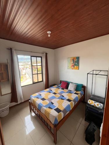 een slaapkamer met een bed en een raam bij Apartamentos casco in Heredia